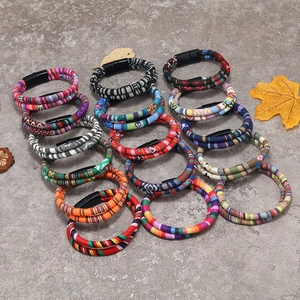 Detail of bohemian woven fabric bracelets with magnetic clasps on a rustic stone background