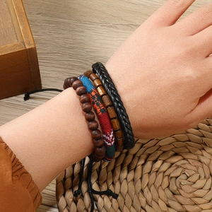 Vue détaillée du lot de quatre bracelets bohèmes avec perles en bois et tissu ethnique tissé