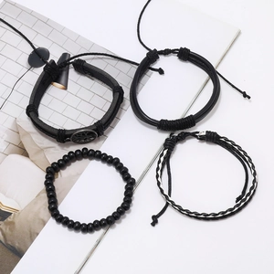 Détails d'un ensemble de quatre bracelets punk noirs avec pendentif arbre de vie et perles