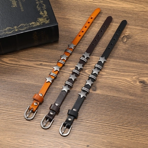 Three-piece punk leather bracelet set with silver star rivets and buckle on wood background