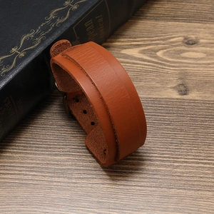 Macro view of brown genuine leather bracelet texture with metallic buckles and rivets