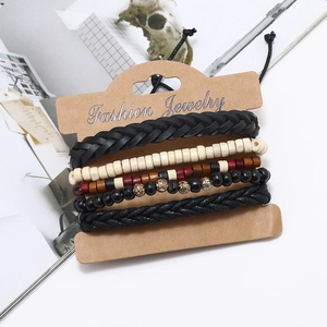 Détail d'un ensemble de cinq bracelets multicouches en cuir tressé et perles de bois sur carte