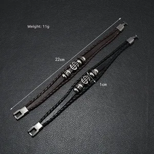 Detail of woven leather bracelets in black and brown featuring a metal dollar sign charm