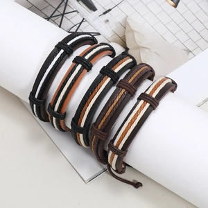 Five-piece set of vintage braided leather bracelets in earthy tones on a white display