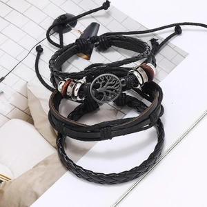 Close-up of tree of life charm, wooden beads, and woven black leather bracelets