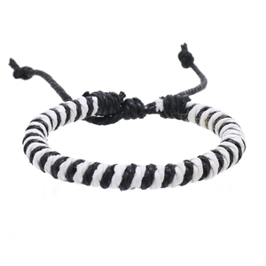 Detail of hand-woven black and white wax cord bracelet with adjustable pull-string knot