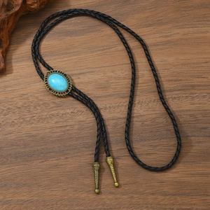 Détail d'une cravate Bolo vintage avec pierre turquoise et embouts en bronze gravés