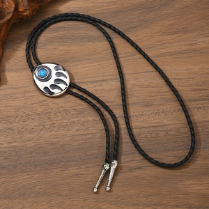 Vintage bear paw bolo tie with blue turquoise inlay on an adjustable black leather cord