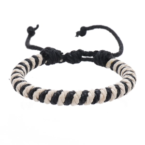 Close-up of black and cream woven wax rope bracelet with adjustable sliding knot detail