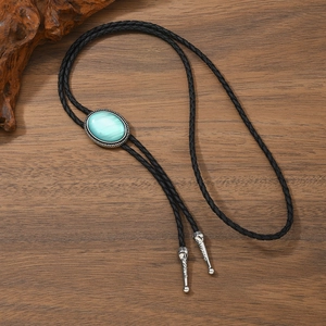 Vintage western bolo tie with green faux gemstone and black braided leather rope