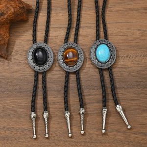 Three vintage Bolo ties with turquoise and tiger eye stones on rustic wood background