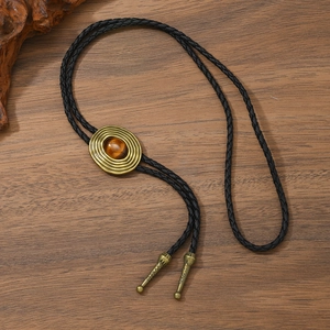 Detail der Vintage-Bolo-Krawatte mit Tigerauge-Stein an geflochtener Lederkordel
