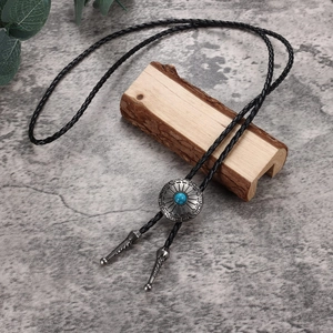 Vintage western bolo tie featuring black braided leather and turquoise metal slide