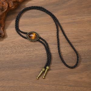 Nahaufnahme der Vintage-Bolo-Krawatte mit Tigerauge-Stein auf Holzuntergrund