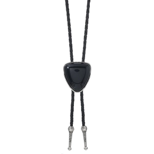 Detail einer Vintage-Bolo-Krawatte mit schwarzem Stein und gravierten Metallspitzen