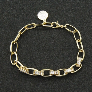 Detailed macro view of gold chain bracelet with rectangle crystal inlaid links and clasp