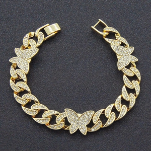 Close-up of gold Cuban chain bracelet with butterfly charms and clear zircon stones