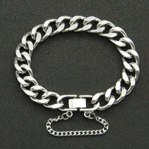 Detail view of silver Cuban chain bracelet with secure fold-over clasp and safety chain