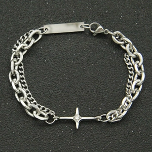 Close-up of silver Cuban link chain bracelet with star pendant and engravable metal tag