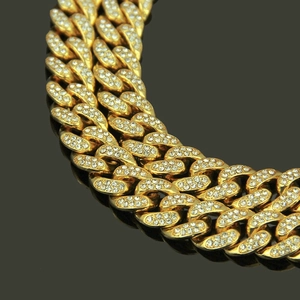 Collier Cuban Link 13mm doré avec boucle papillon en strass sur fond noir élégant
