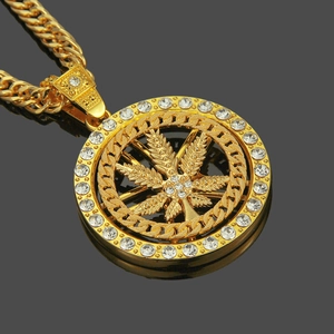 Dettaglio macro della collana con ciondolo a foglia d'acero rotante e catena cubana