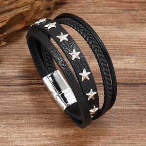 Detail of multi-layer black leather bracelet with silver star studs and magnetic clasp