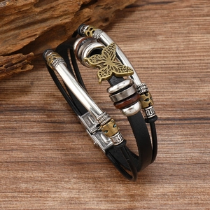 Close-up of multilayer leather bracelet featuring bronze butterfly and stainless steel clasp