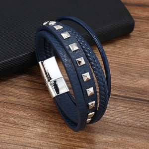 Detail of navy blue multi-layer leather bracelet with silver pyramid studs and magnetic buckle