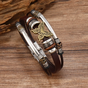 Detail of multilayer leather bracelet featuring bronze butterfly charm and vintage metal beads