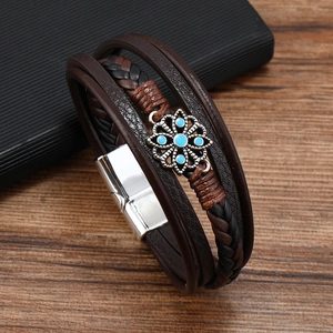 Dettaglio del bracciale in pelle intrecciata multistrato con fiore e chiusura magnetica