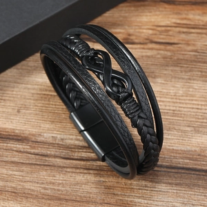 Macro shot of multi-layer black braided leather bracelet with infinity symbol and matte clasp