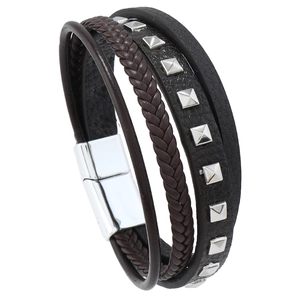Detail of multi-layer leather bracelet featuring woven straps and silver pyramid studs