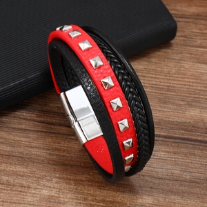 Detail of multi-layer leather bracelet with red studded strap and silver magnetic clasp