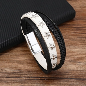 Macro detail of multi-layer leather bracelet with silver star studs and magnetic clasp