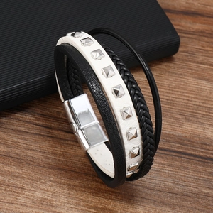 Close-up of multilayer leather bracelet featuring silver magnetic clasp and metal studs