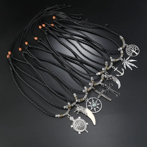 Detailed overhead view of assorted vintage alloy pendants on black braided cords