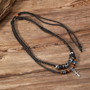 Retro double-layer beaded cross pendant necklace for men on a dark wood background