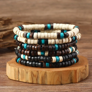 Close-up of bohemian turquoise and wooden Heishi beaded bracelets on a natural wood stand