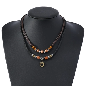 Vintage layered wooden bead necklace with bronze heart pendant on a display neck model