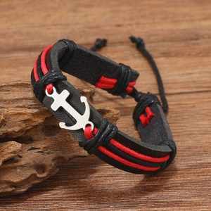 Macro shot of handcrafted leather anchor bracelet with nautical silver charm and red ropes