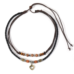 Vintage bohemian layered wooden bead necklace with bronze heart pendant on white background