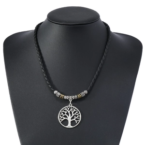 Detail of tree of life pendant and vintage metal beads on a black woven cord necklace