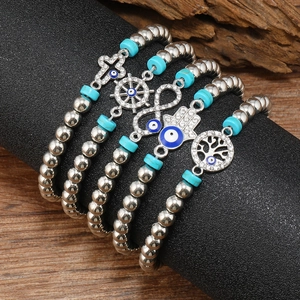 Ensemble de 4 bracelets perlés argentés avec détails turquoise et breloques œil bleu