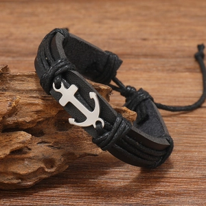 Close-up of black leather woven bracelet with silver anchor charm and adjustable cords