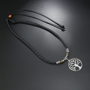 Detail of tree of life pendant on black braided rope with vintage metallic beads