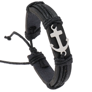 Macro detail of men's black leather braided bracelet with a silver anchor charm