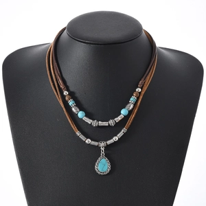 Detail of bohemian layered necklace with turquoise stones and vintage silver metal accents