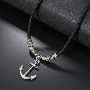 Macro shot of silver anchor pendant with retro metal beads on black braided leather cord