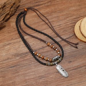 Collier multicouche vintage avec pendentif plume, perles en bois et cordon en cuir tressé
