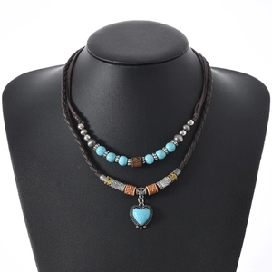 Detail of bohemian double-layer necklace with turquoise heart pendant on black mannequin